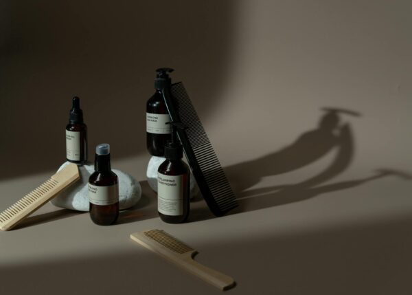 Minimalist display of beauty products, combs, and natural elements on a neutral background.